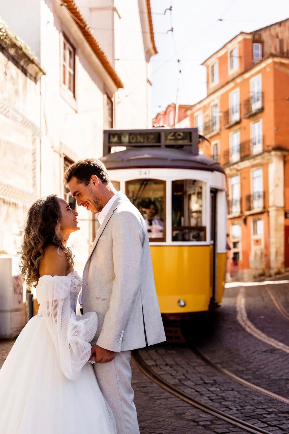 Noivos junto a um elétrico amarelo típico de Lisboa